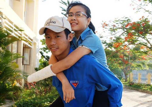 Bị tai nạn gãy tay và chân, thí sinh Nguyễn Thị Hồng Trinh được tình nguyện viên cõng lên phòng thi - d