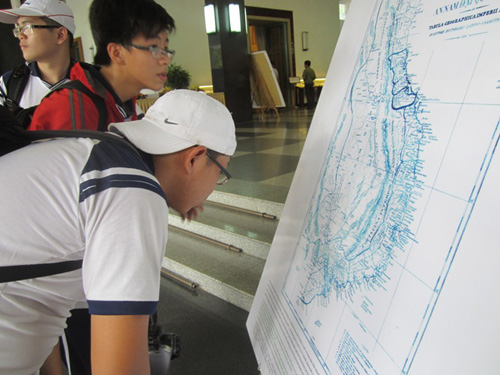 Các học sinh chăm chú xem triển lãm về bản đồ Việt Nam
