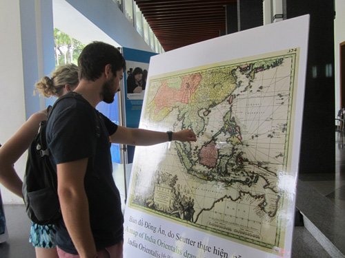 Du khách nước ngoài đang tìm kiếm quần đảo Trường Sa trên tấm bản đồ cũ