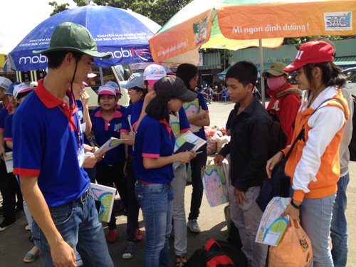 Sinh viên tình nguyện tặng bản đồ thành phố và hướng dẫn cho thí sinh tại bến xe Miền Đông năm 2013