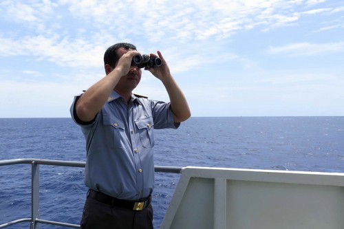 Thuyền trưởng Lê Minh Phúc của tàu Kiểm ngư KN-22 đang quan sát khu vực Trung Quốc đặt trái phép giàn khoan bằng ống nhòm