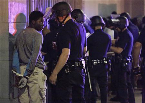 Cảnh sát bắt những người tham gia biểu tình bạo động tại Ferguson hồi tháng 8 - Ảnh: Reuters