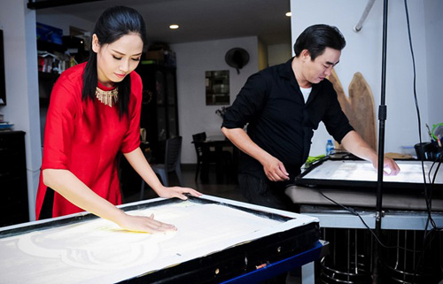 Hoa hậu Nguyễn Thị Loan học vẽ tranh cát với Trí Đức - Ảnh: Chí Linh