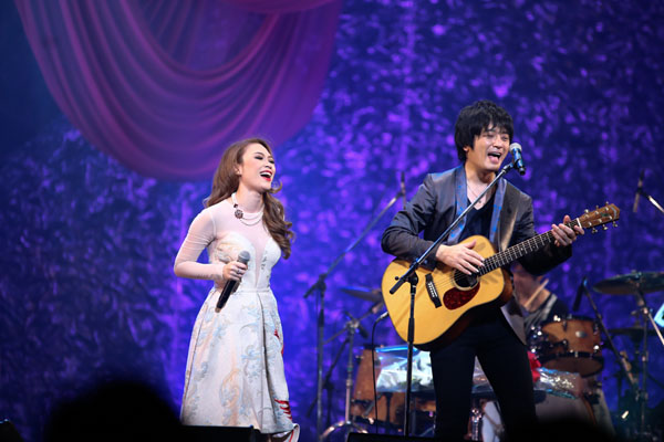 Oshio Kotaro hát tiếng Việt và bè giúp Mỹ Tâm khi cô thể hiện ca khúc Họa mi tóc nâu bên cạnh việc đệm guitar