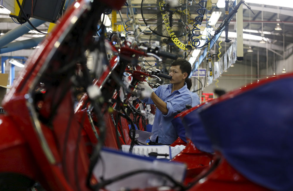 Công nhân làm việc trong nhà máy của Tập đoàn Piaggio (Ý) ở tỉnh Vĩnh Phúc - Ảnh: Reuters