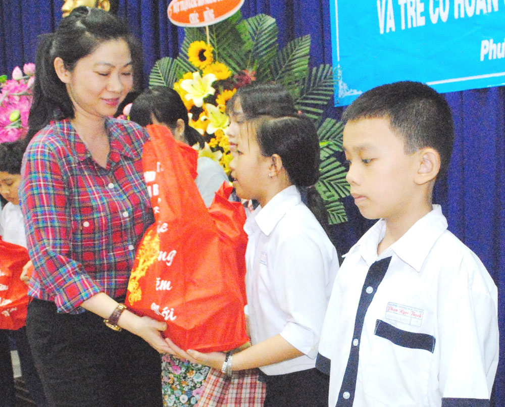 Bà Thái Thị Lan Chi, Bí thư Đảng ủy P.14, trao quà cho các em nhỏ - Ảnh: Bùi Chiến