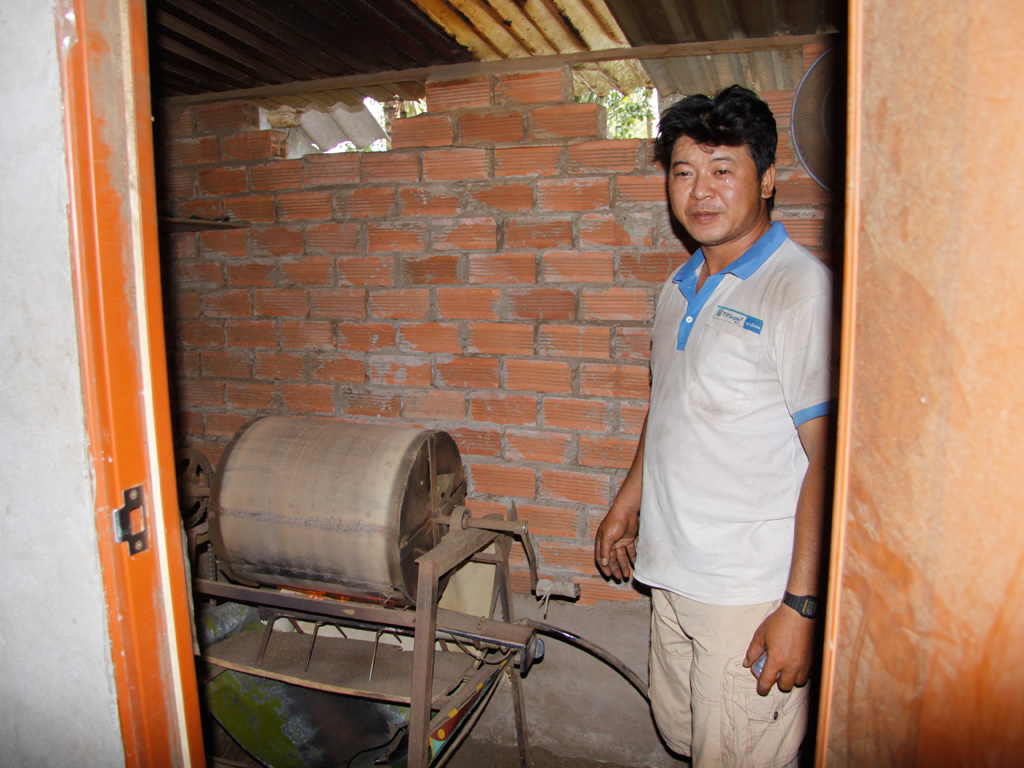 Anh Nhơn bên chiếc máy sấy đậu phộng do mình chế tạo - Ảnh: Thanh Đức
