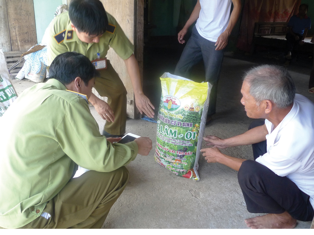 Cơ quan Quản lý thị trường Lạng Sơn kiểm tra loại phân bị người dân nghi là giả mạo - Ảnh: Lê Thanh Hiền