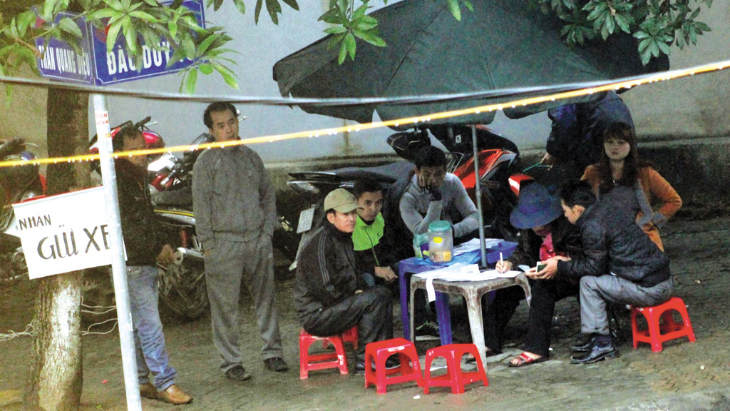 “Cò mồi” ngang nhiên đặt bàn ghi hồ sơ, chụp ảnh, giữ xe - Ảnh: Phạm Đức