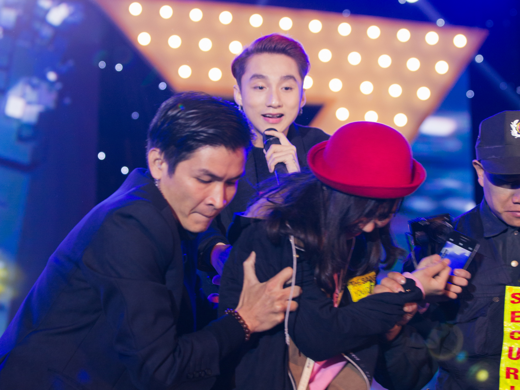 Một fan nữ phá vòng vây, leo lên sân khấu để tặng hoa cho Sơn Tùng