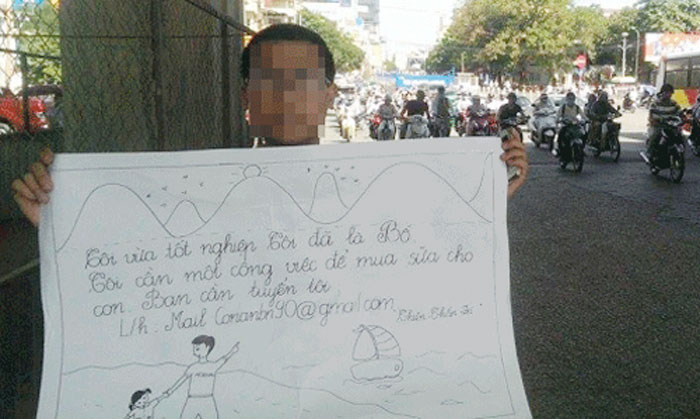 Ông bố trẻ cầm biển đứng ngoài đường xin việc - Ảnh chụp màn hình Facebook