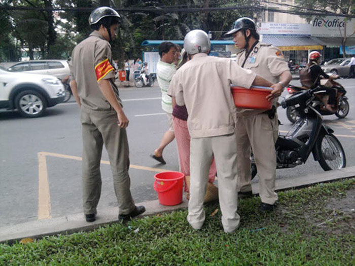 Lực lượng chức năng 'hốt hàng' của người bán rong trên vỉa hè - Ảnh: Công Nguyên