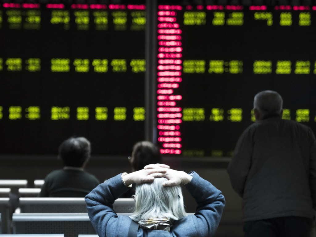 Nhà đầu tư tại một công ty chứng khoán ở Bắc Kinh - Ảnh: AFP