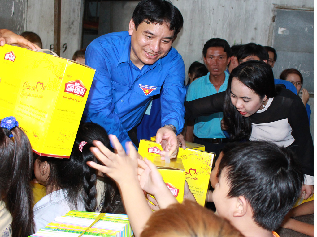 Bí thư thứ nhất T.Ư Đoàn Nguyễn Đắc Vinh tặng tập vở cho trẻ em nghèo lớp học tình thương - Ảnh: Lê Thanh