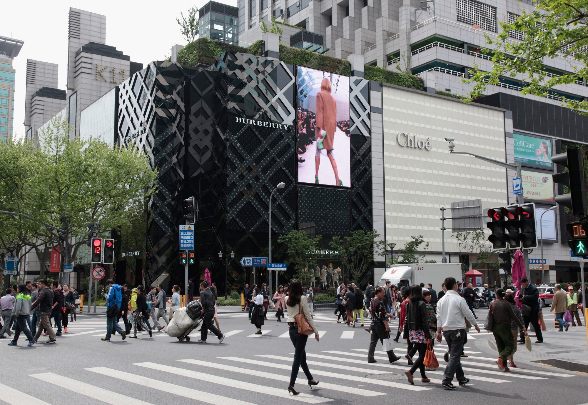 Pedestrians walk by the Burberry store in Shanghai