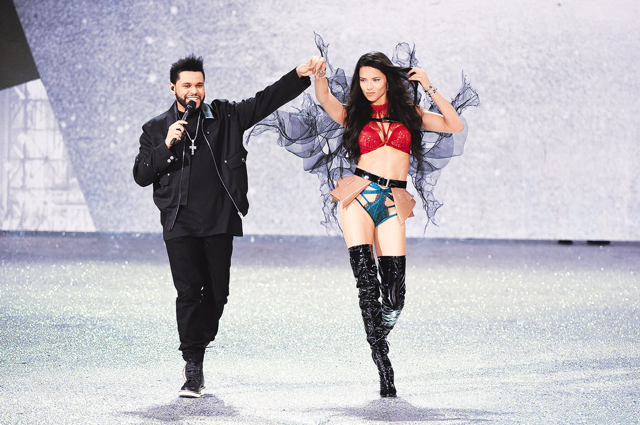Singer Weeknd and Adriana Lima walk the runway during