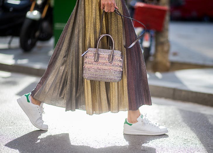 woman-wearing-a-long-pleated-skirt-and-white-sneakers