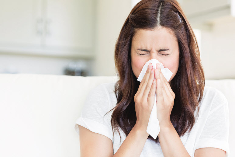 Brunette-sneezing-in-a-tissue