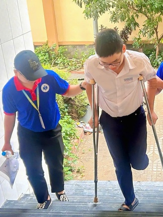 Thí sinh bị gãy chân, di chuyển bằng nạng được tình nguyện viên tận tình hỗ trợ