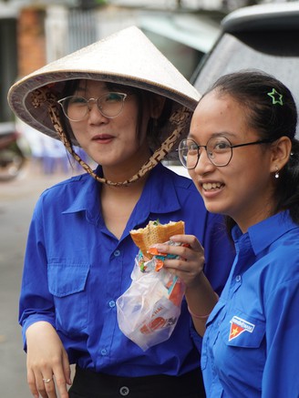 Tình nguyện viên tranh thủ 'gặm bánh mì', túc trực tiếp sức thí sinh