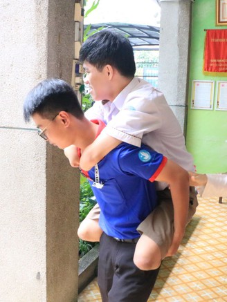 Tình nguyện viên cõng thí sinh mất tay, chân đi thi tốt nghiệp THPT 2025