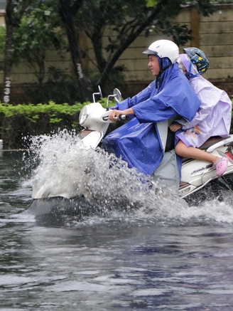 TP.HCM có mưa rất to chiều nay: Nước ngập gần hết bánh xe, người dân 'vượt sóng'