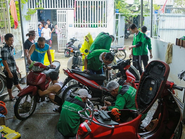Sinh viên sửa xe máy miễn phí cho người dân vùng ngập lụt - Ảnh 1.