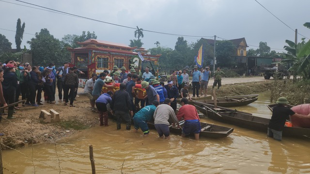 Đường ra nghĩa trang ngập sâu, dân dùng thuyền chở quan tài người chết đi chôn cất - Ảnh 2.