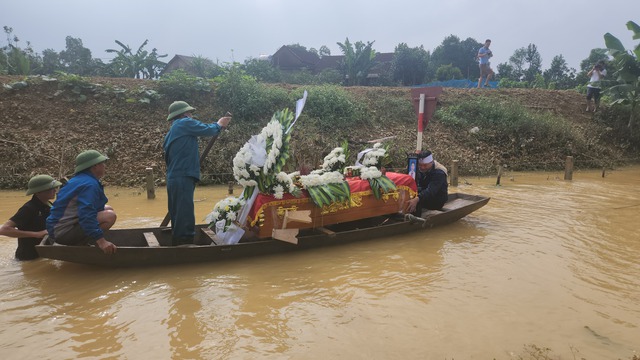 Đường ra nghĩa trang ngập sâu, dân dùng thuyền chở quan tài người chết đi chôn cất - Ảnh 3.