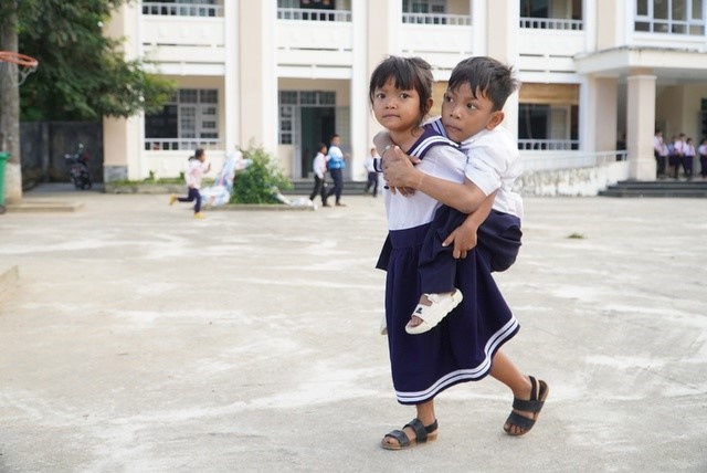 Cô bé lớp 1 cõng bạn đến trường - Ảnh 1. Cô bé lớp 1 cõng bạn đến trường - Ảnh 1.