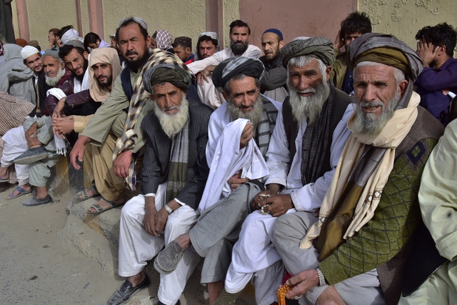 Người di cư Afghanistan ngày 2.11 ngồi chờ bên ngoài lãnh sự quán Afghanistan tại Quetta, Pakistan để nhận giấy hồi hương