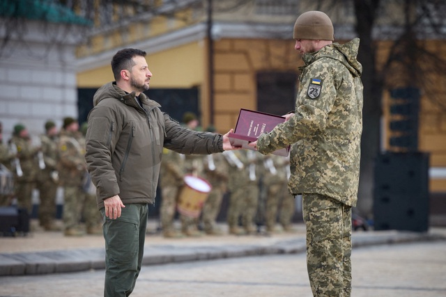 Ông Zelensky trao lá cờ cho quân nhân trong buổi lễ ngày 24.2 tại Kyiv