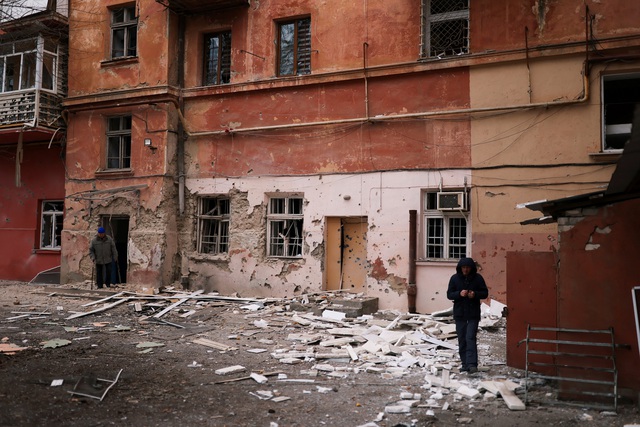 Người dân Kherson ngoài căn hộ chung cư bị đạn pháo phá hủy ngày 25.1