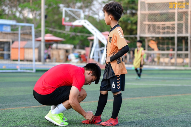 Cựu tuyển thủ U.23 Việt Nam Nguyễn Thanh Bình cột giày cho 1 học viên nhí