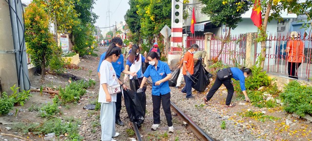 Người dân TP.HCM tái chế bình nhựa trồng hoa dọc tuyến đường sắt - Ảnh 1.