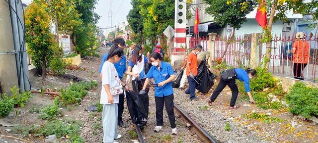 Người dân TP.HCM tái chế bình nhựa trồng hoa dọc tuyến đường sắt - Ảnh 1.