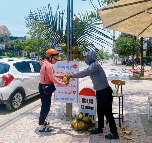 Nắng nóng, quán cà phê mời người qua đường ghé 'hái trái dừa' uống miễn phí - Ảnh 1.