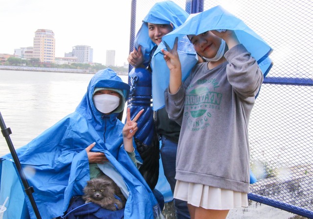 Đà Nẵng: Người dân đội mưa xí chỗ bên bờ sông Hàn xem pháo hoa   - Ảnh 1.