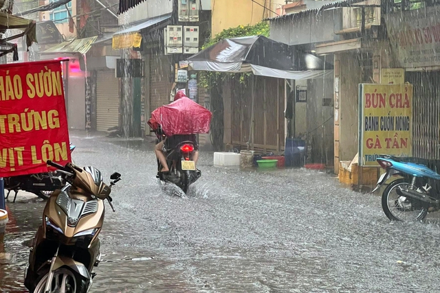 Đường phố Hà Nội ngập sâu trong cơn mưa lớn đầu mùa - Ảnh 7.
