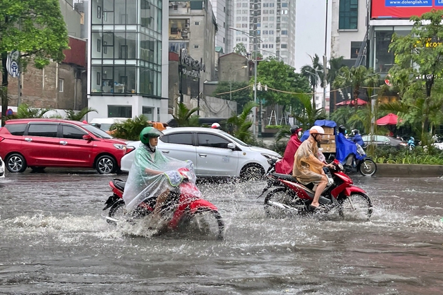 Đường phố Hà Nội ngập sâu trong cơn mưa lớn đầu mùa - Ảnh 10.
