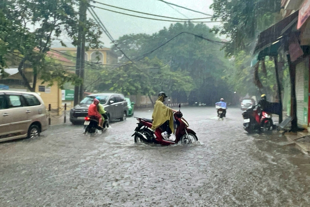 Đường phố Hà Nội ngập sâu trong cơn mưa lớn đầu mùa - Ảnh 4.