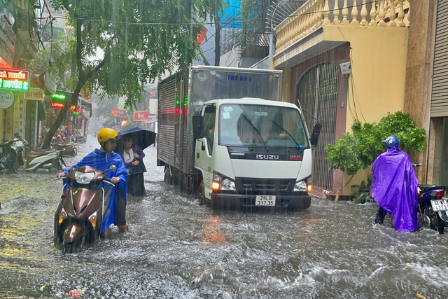 Đường phố Hà Nội ngập sâu trong cơn mưa lớn đầu mùa - Ảnh 3.