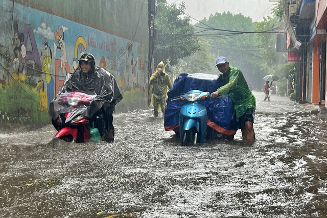 Đường phố Hà Nội ngập sâu trong cơn mưa lớn đầu mùa - Ảnh 2.