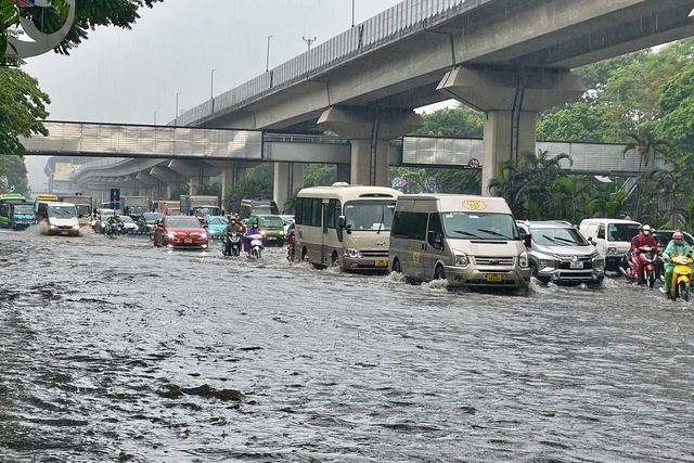 Đường phố Hà Nội ngập sâu trong cơn mưa lớn đầu mùa - Ảnh 1.