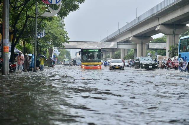 Đường phố Hà Nội ngập sâu trong cơn mưa lớn đầu mùa - Ảnh 8.