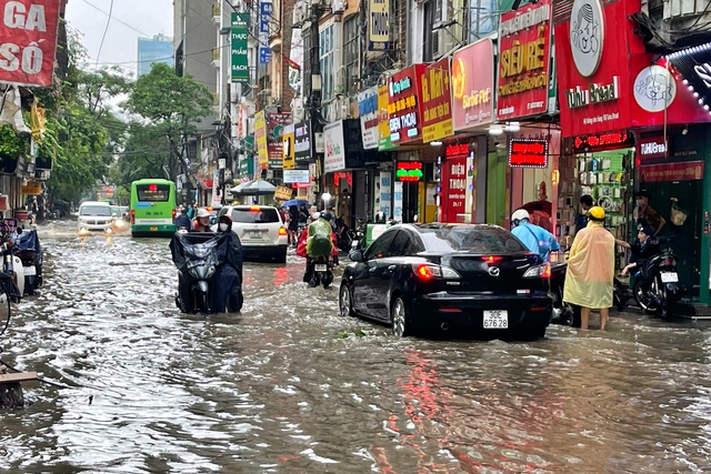 Đường phố Hà Nội ngập sâu trong cơn mưa lớn đầu mùa - Ảnh 6.