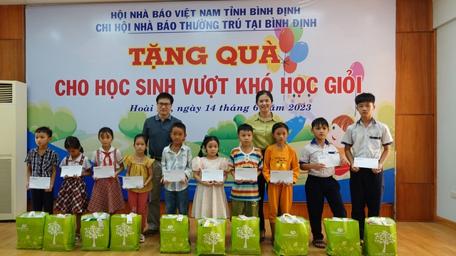 Lãnh đạo Huyện ủy Hoài Ân và Chi hội Nhà báo thường trú tại Bình Định trao quà cho các học sinh