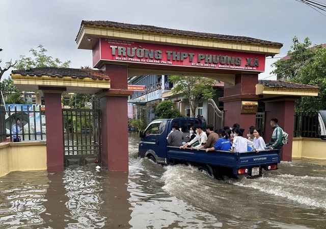 Cổng trường ngập sâu, công an dùng xe chuyên dụng đưa thí sinh vào phòng thi - Ảnh 1.