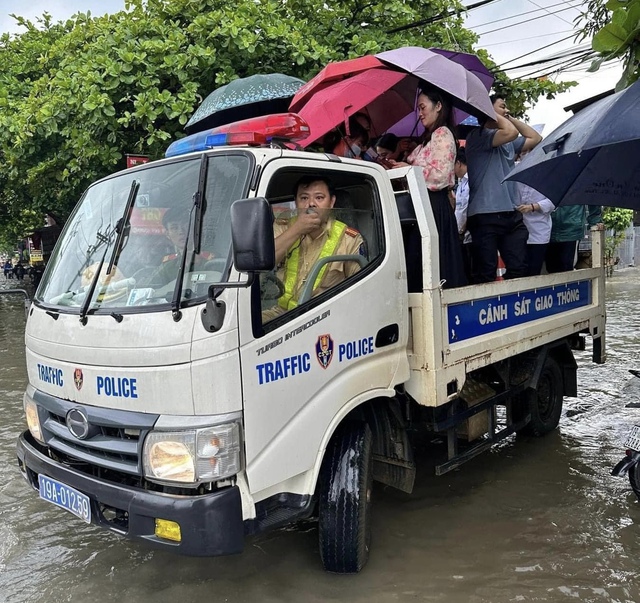 Cổng trường ngập sâu, công an dùng xe chuyên dụng đưa thí sinh vào phòng thi - Ảnh 3.