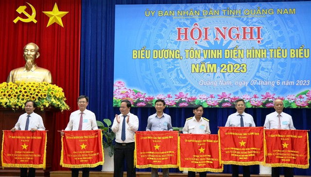 Giám đốc PC Quảng Nam Nguyễn Hữu Khánh (thứ hai, trái) đón nhận cờ. (ẢNH: VIỆT HẢO).